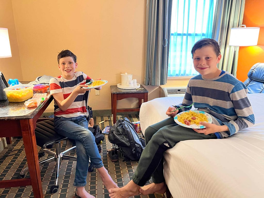 boys eating macaroni and cheese in a hotel