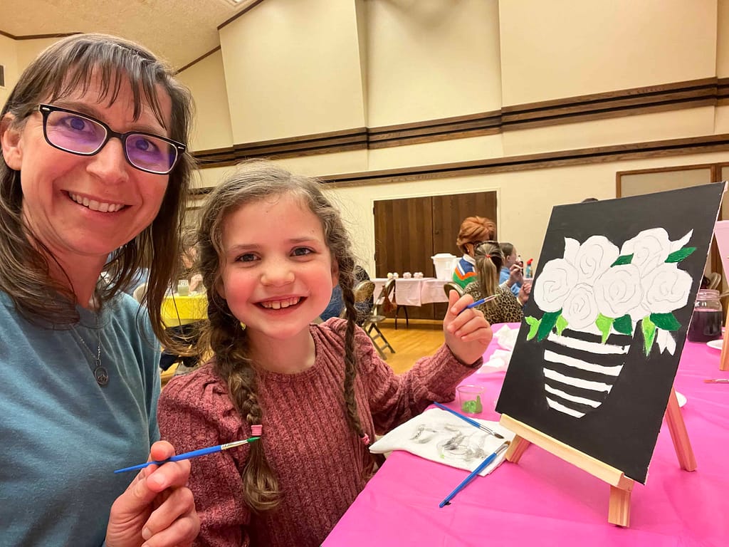 mom and daughter painting at a class
