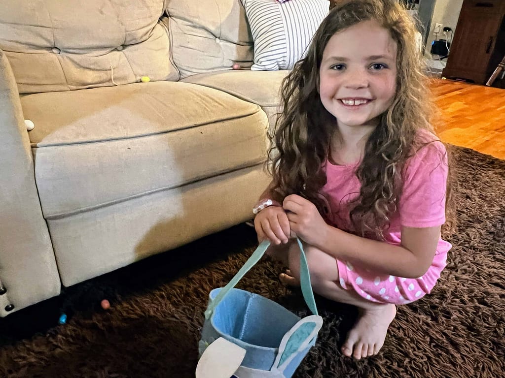 girl looking for Easter candy by the couch