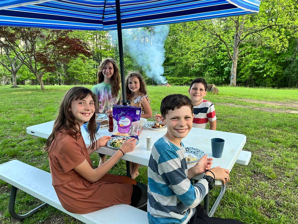 kids eating dinner at a picnic table