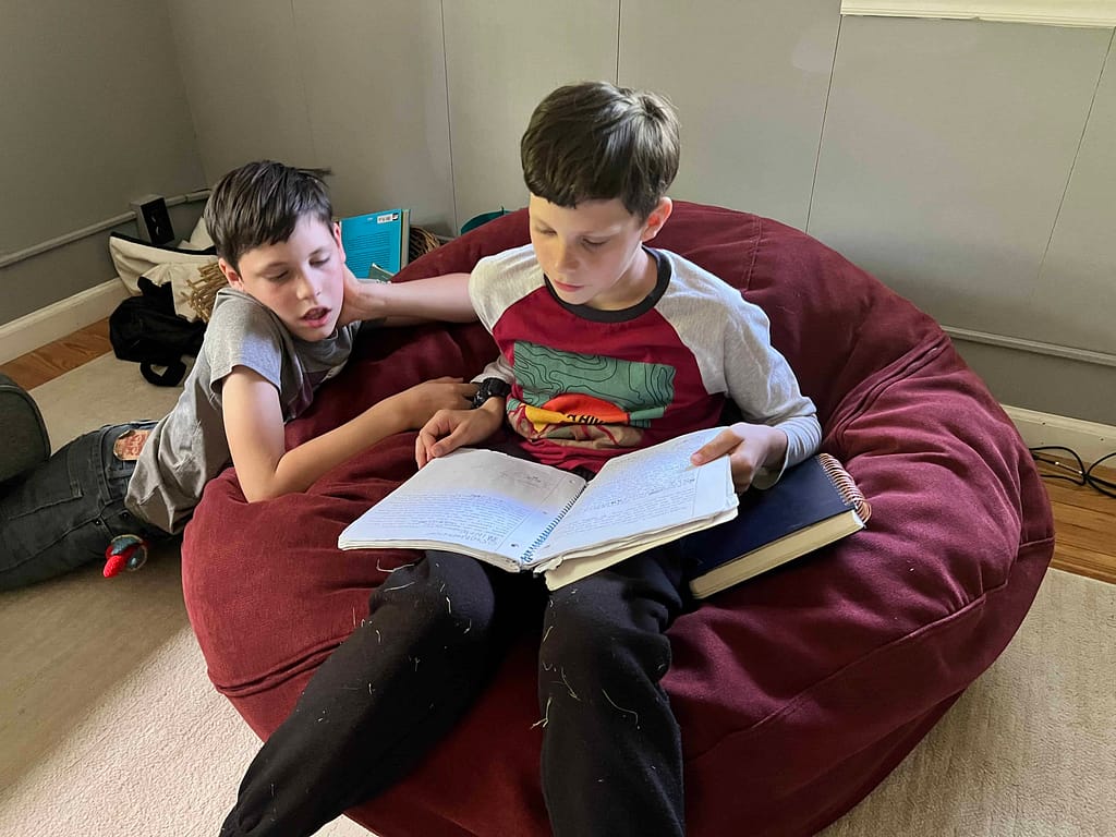 two boys reading on a bean bag chair