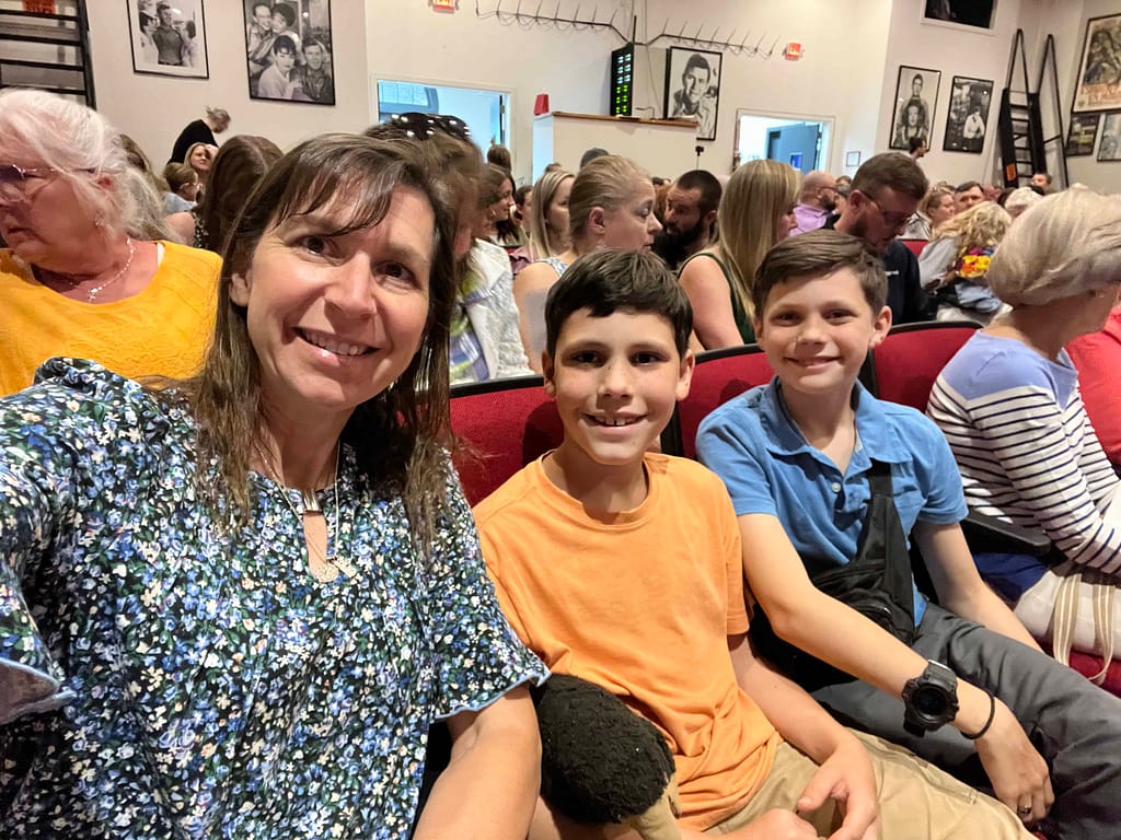 mom and 2 boys watching a play