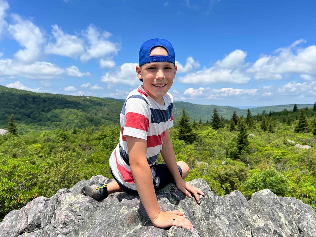 9 year old boy sitting on a boulder