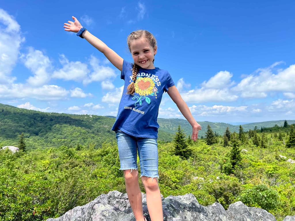 7 year old girl standing on top of a boulder