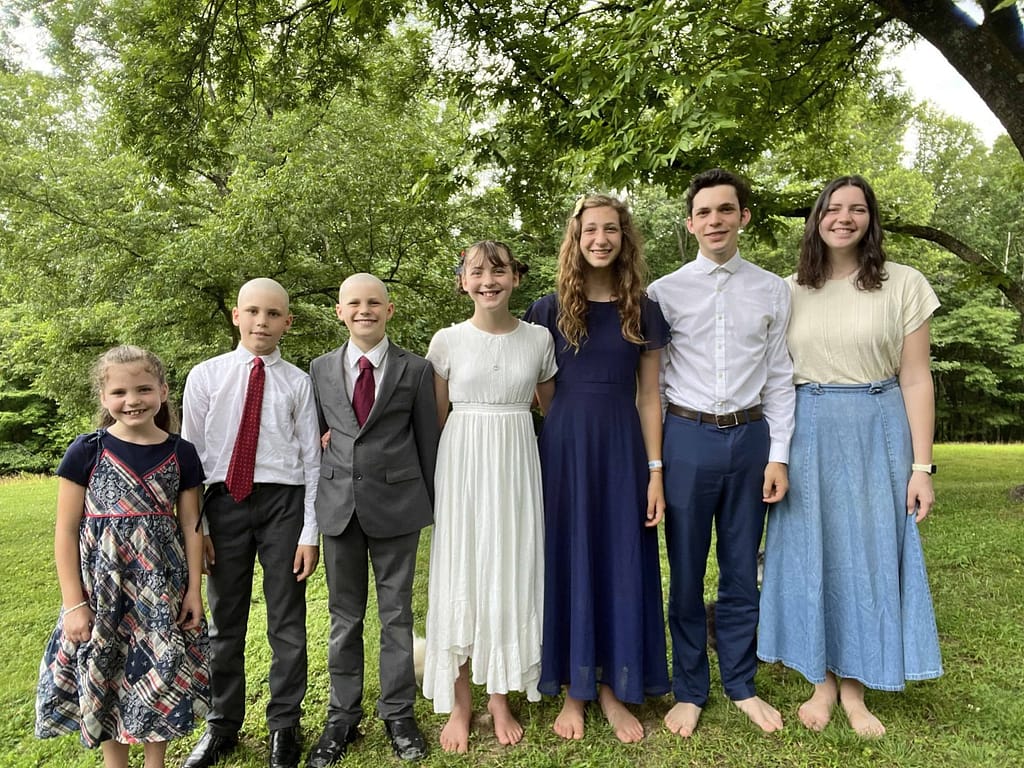 seven kids in age order in patriotic clothing