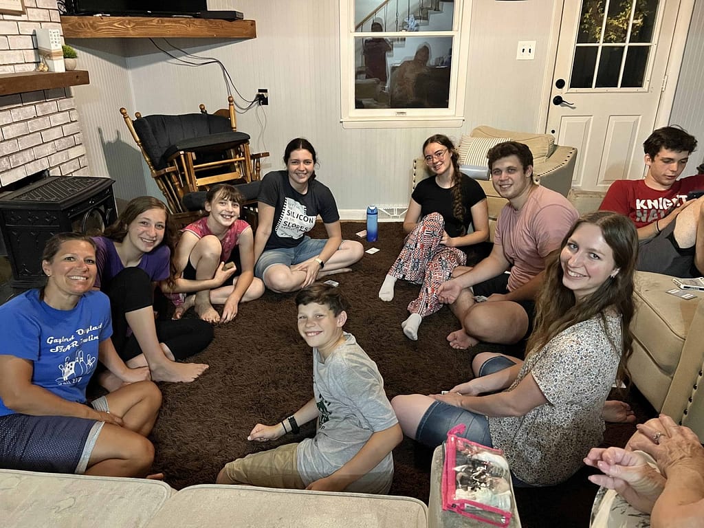 10 siblings playing cards in the living room
