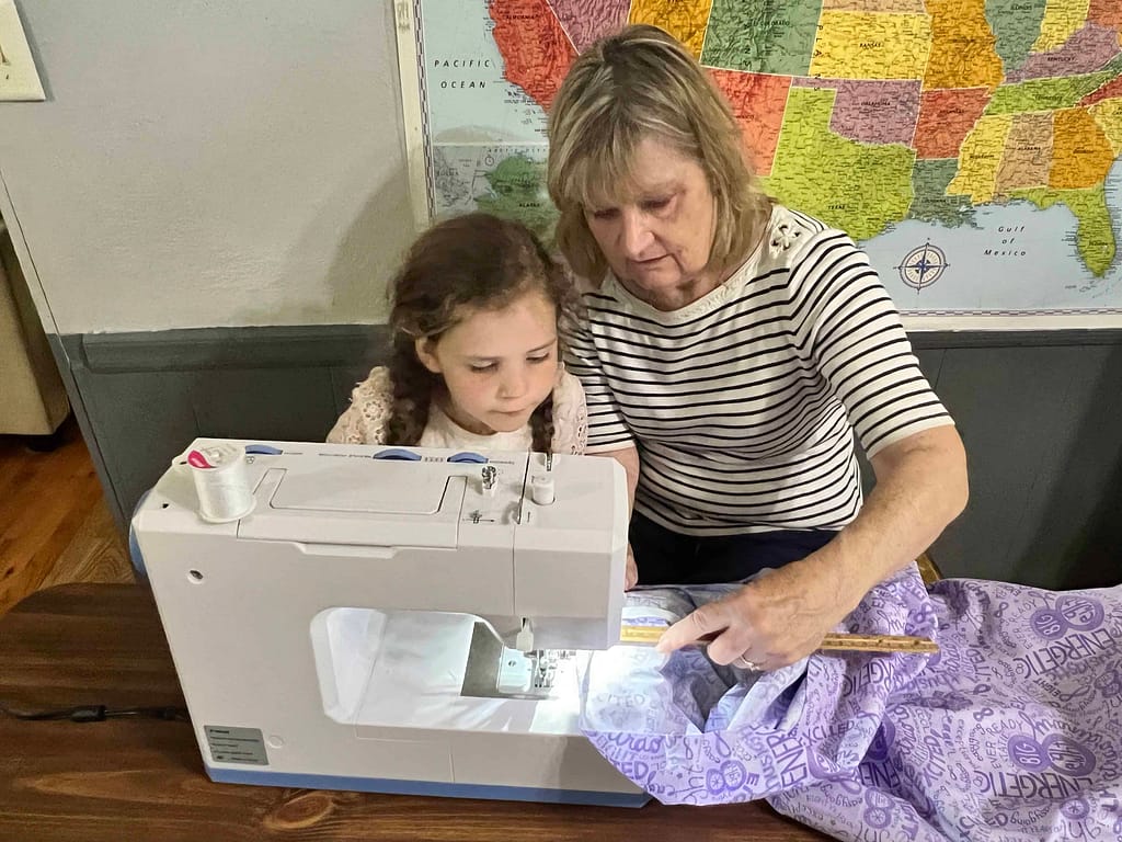 girl sewing with her grandma