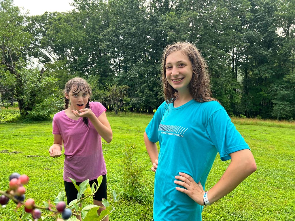 teen sisters eating blueberries in the rain