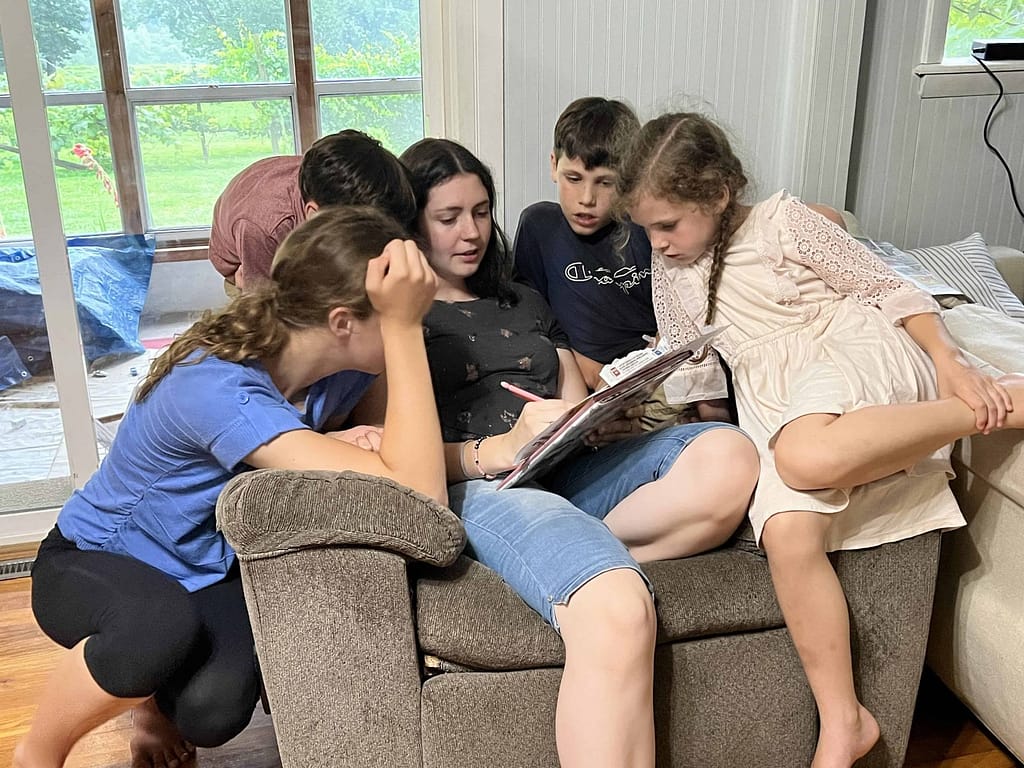 kids gathered around older sibling on the couch