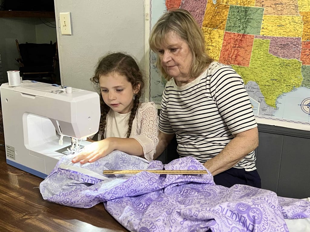 girl and grandma sewing