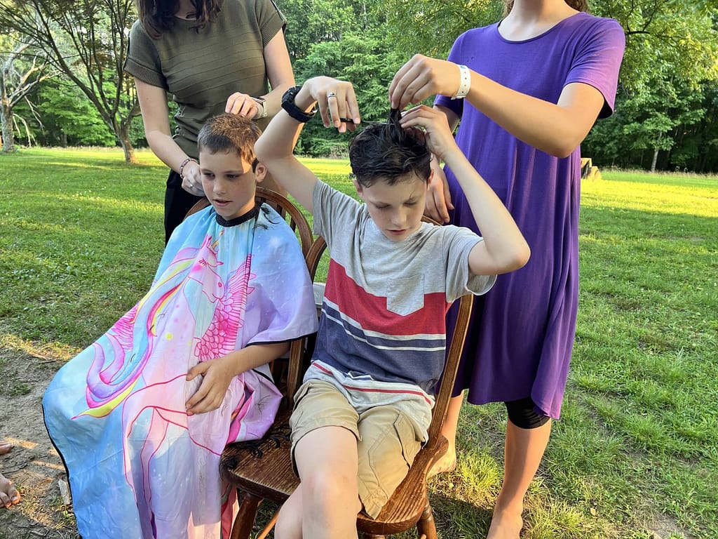two sisters cutting their two brothers hair