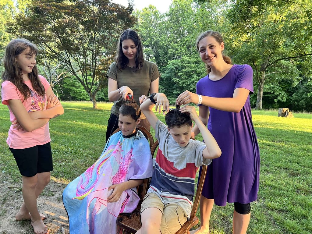 two sisters cutting two brothers hair