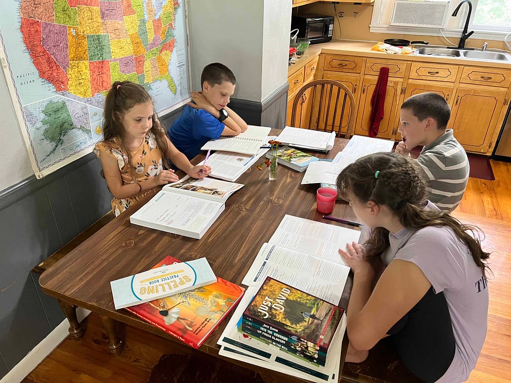 4 kids doing homeschool at the table