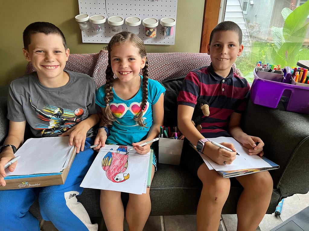 3 kids drawing macaws