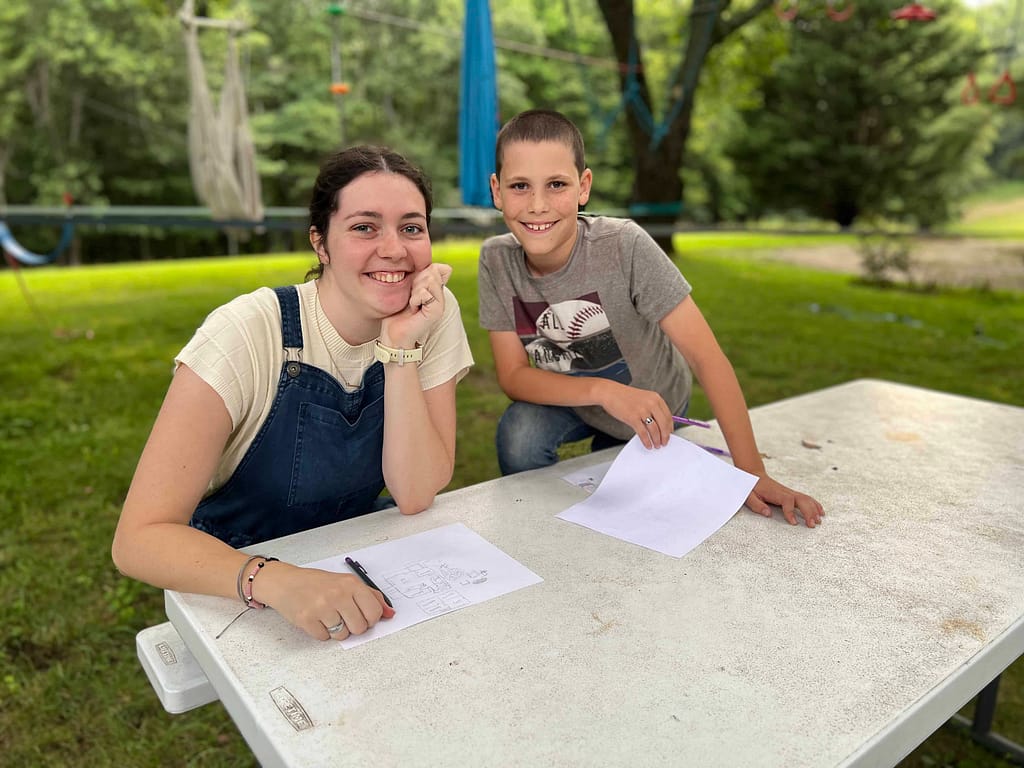 college age sister with 9 year old brother at picnic table