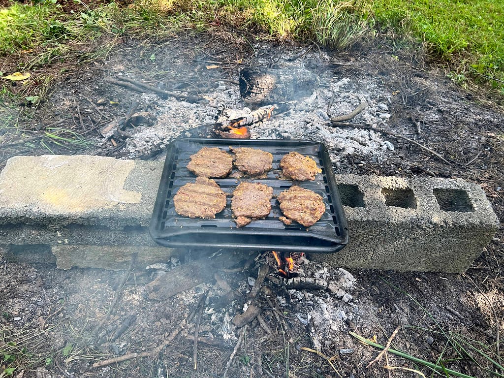 hamburgers cooking over a fire