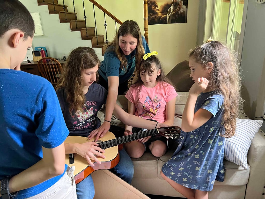 kids gathered around a guitar