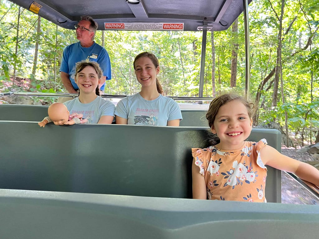 siblings riding on tram at zoo