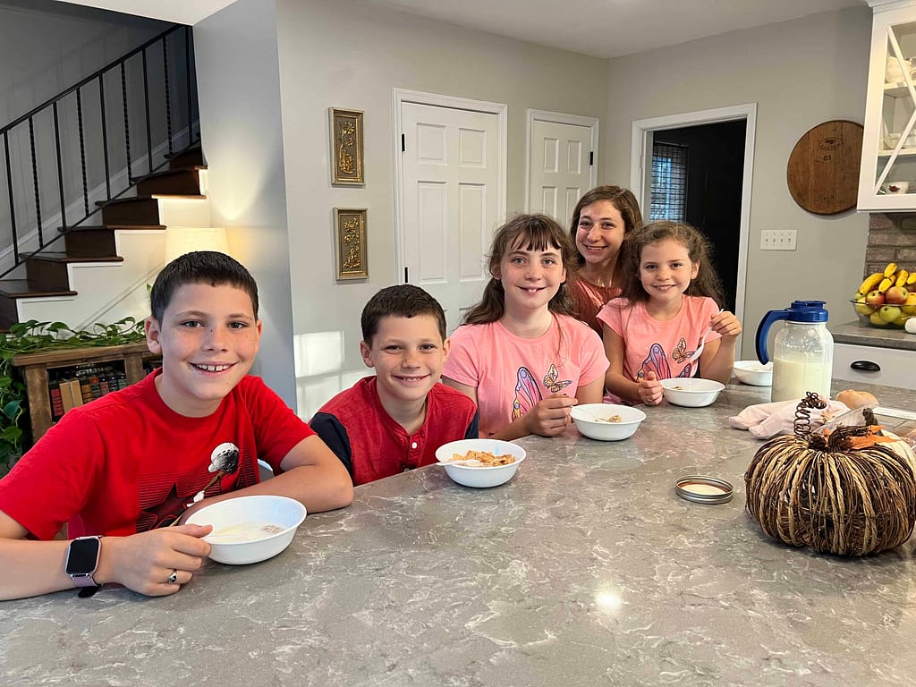 5 kids eating breakfast at a kitchen island