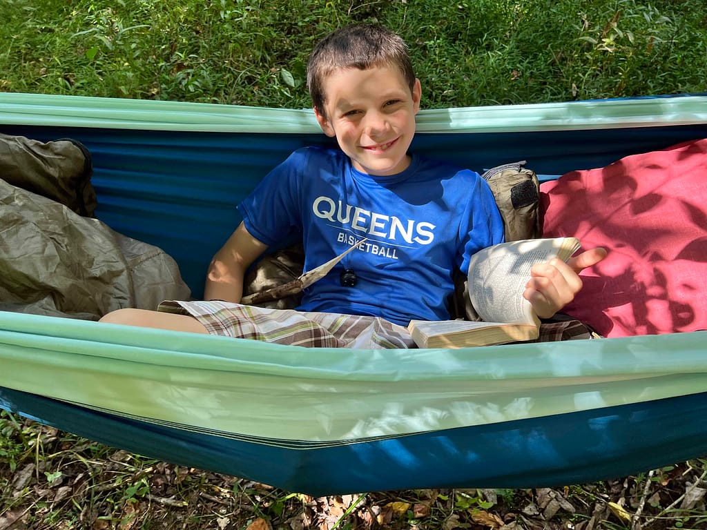 boy reading in hammock