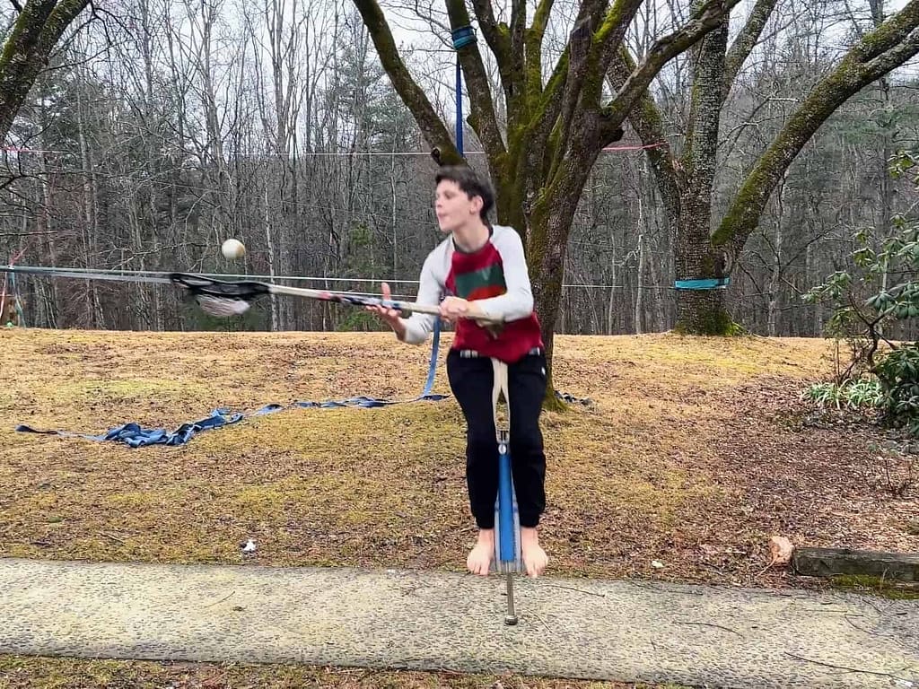 boy playing lacrosse on a Pogo stick