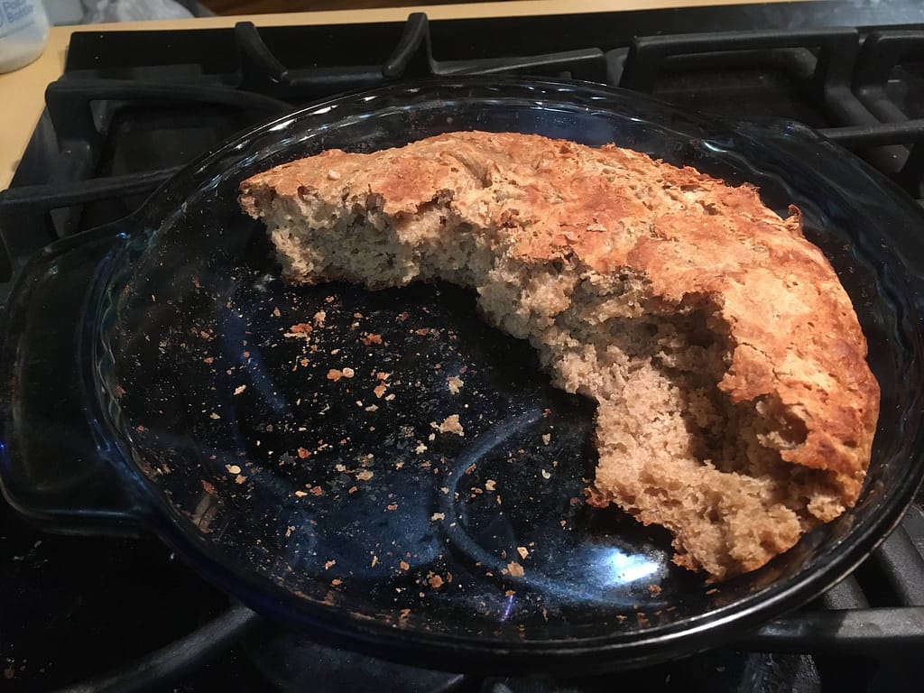 pan of half eaten sourdough bread kids had ripped pieces off of and eaten.
