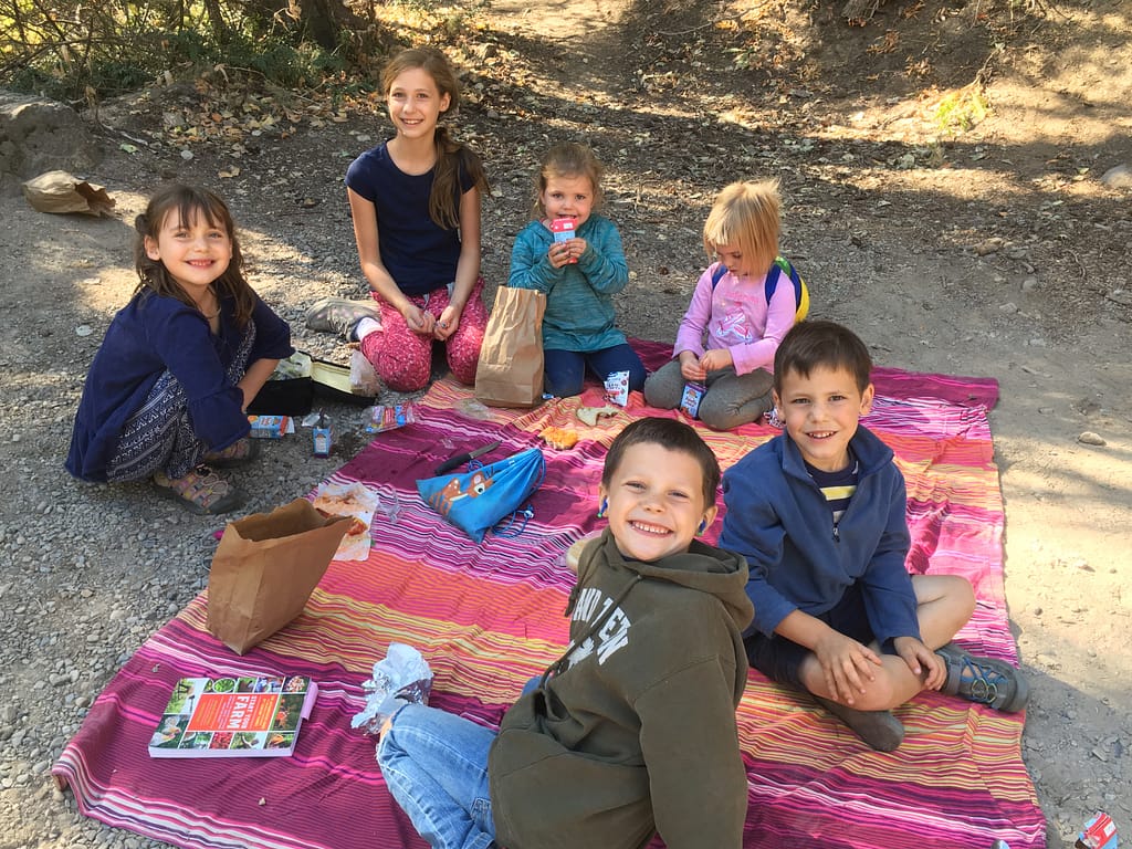 6 kids eating lunch at nature school at donut falls in the canyon