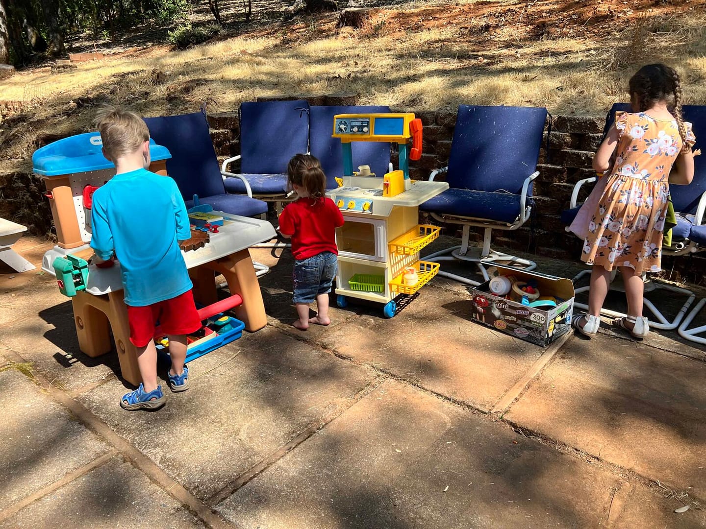 kids playing with a kitchen set outside