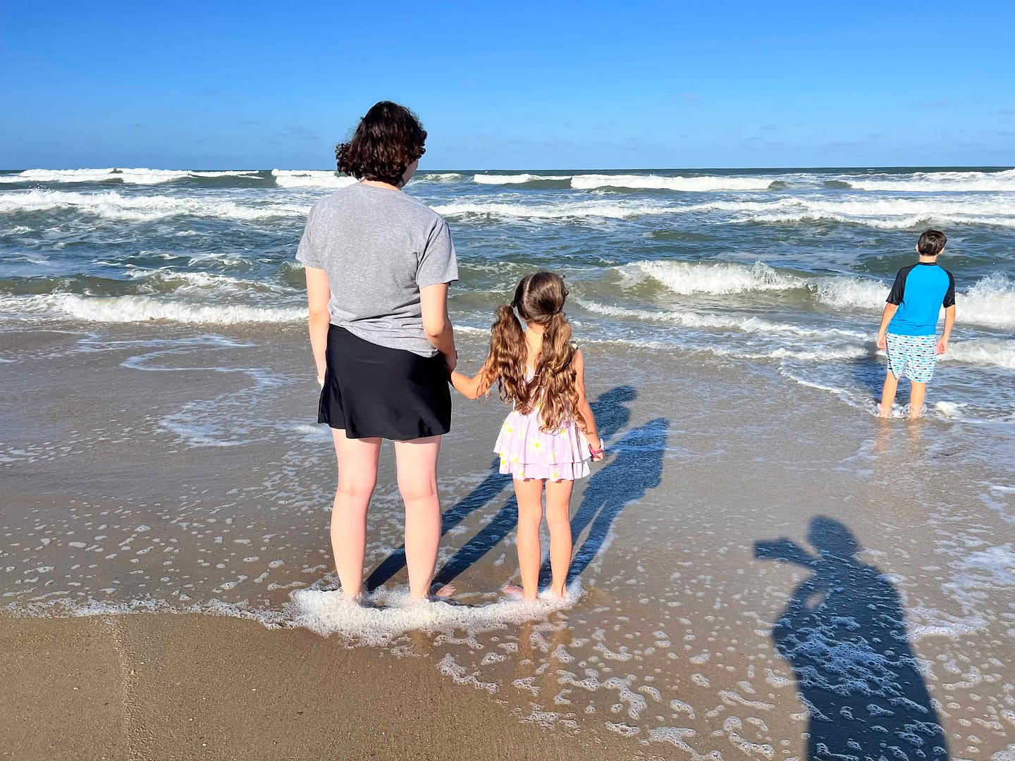 sisters standing on beach