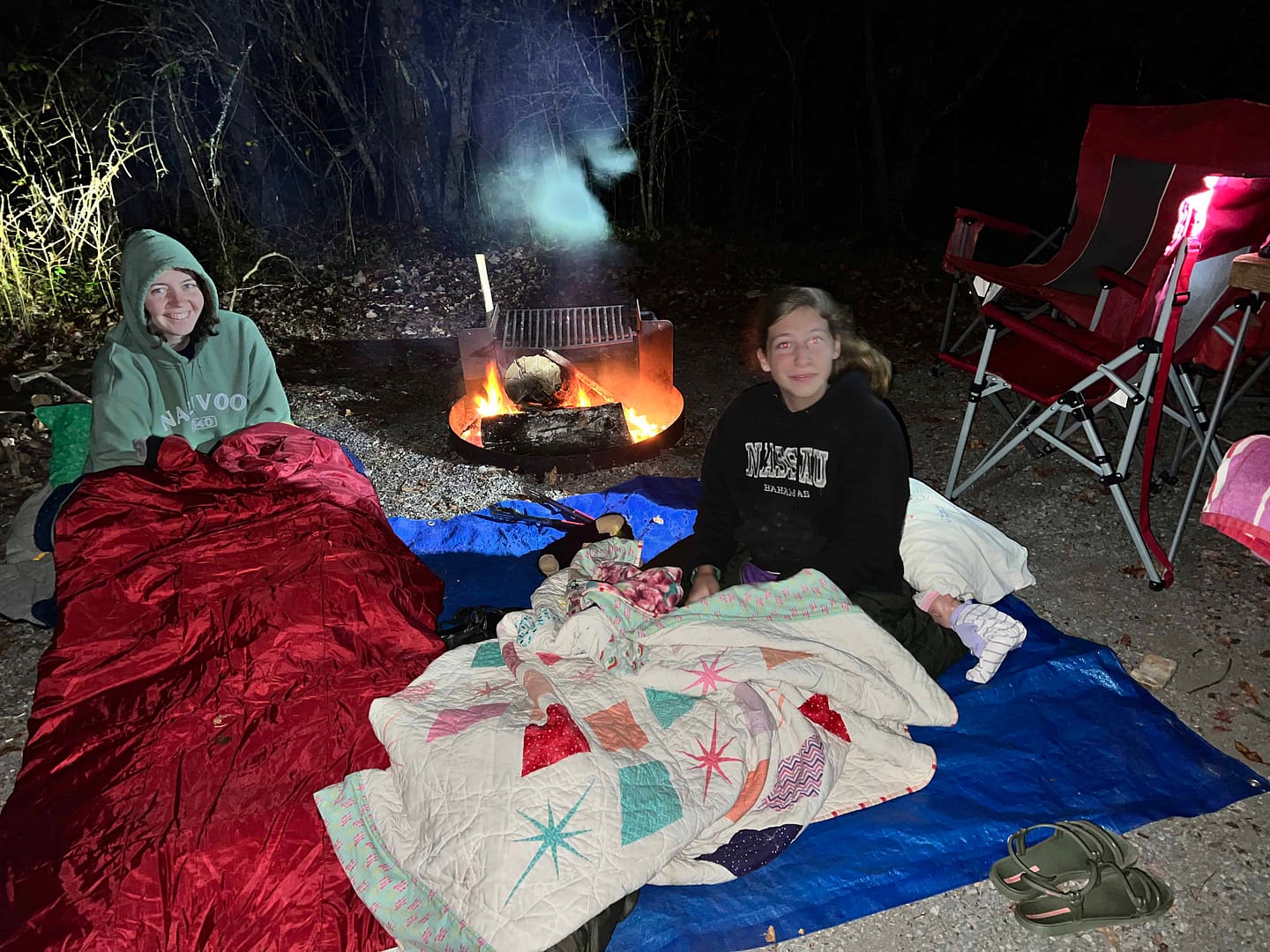 2 sisters sleeping around a campfire