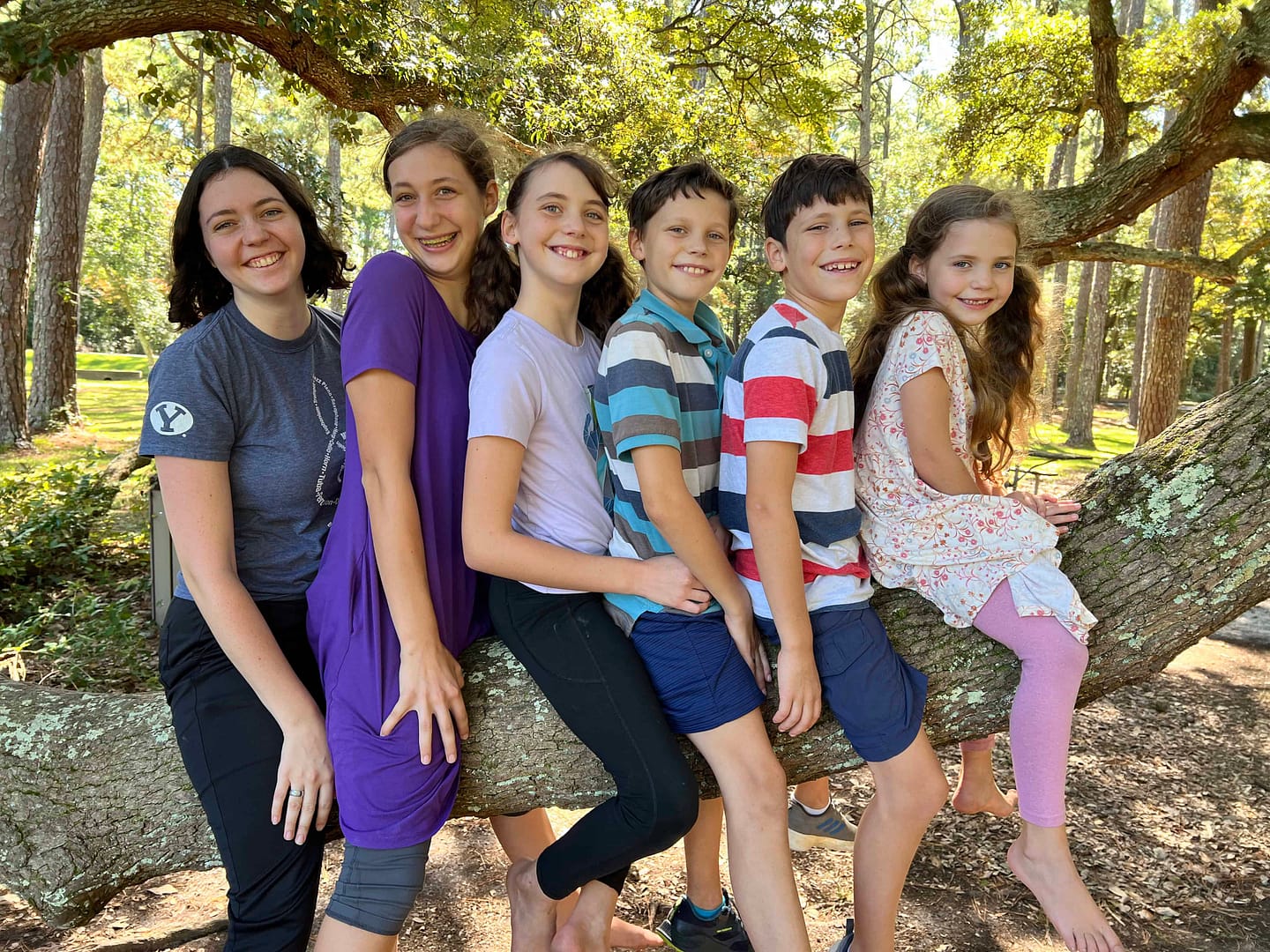 siblings sitting on tree at Ft. Raleigh