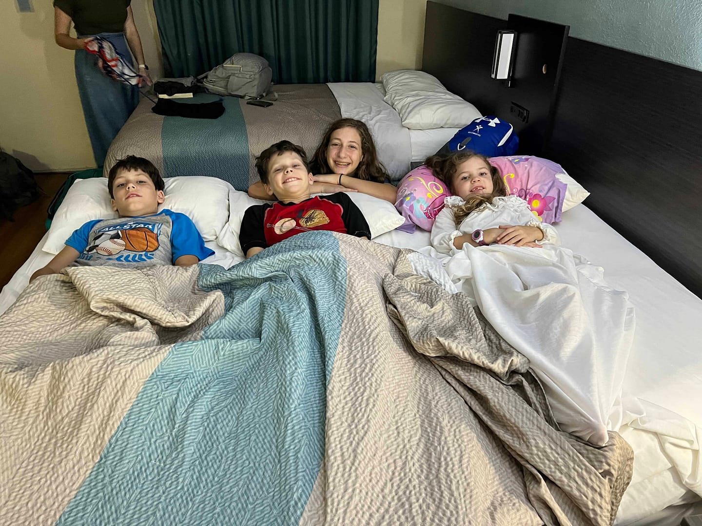 kids sleeping in a motel bed sideways