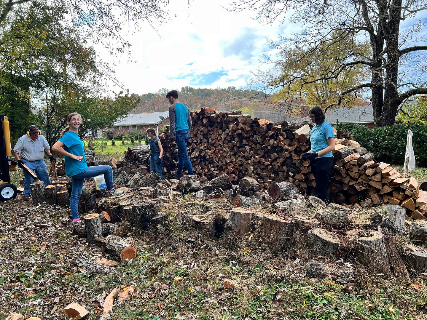 three kids stacking firewood