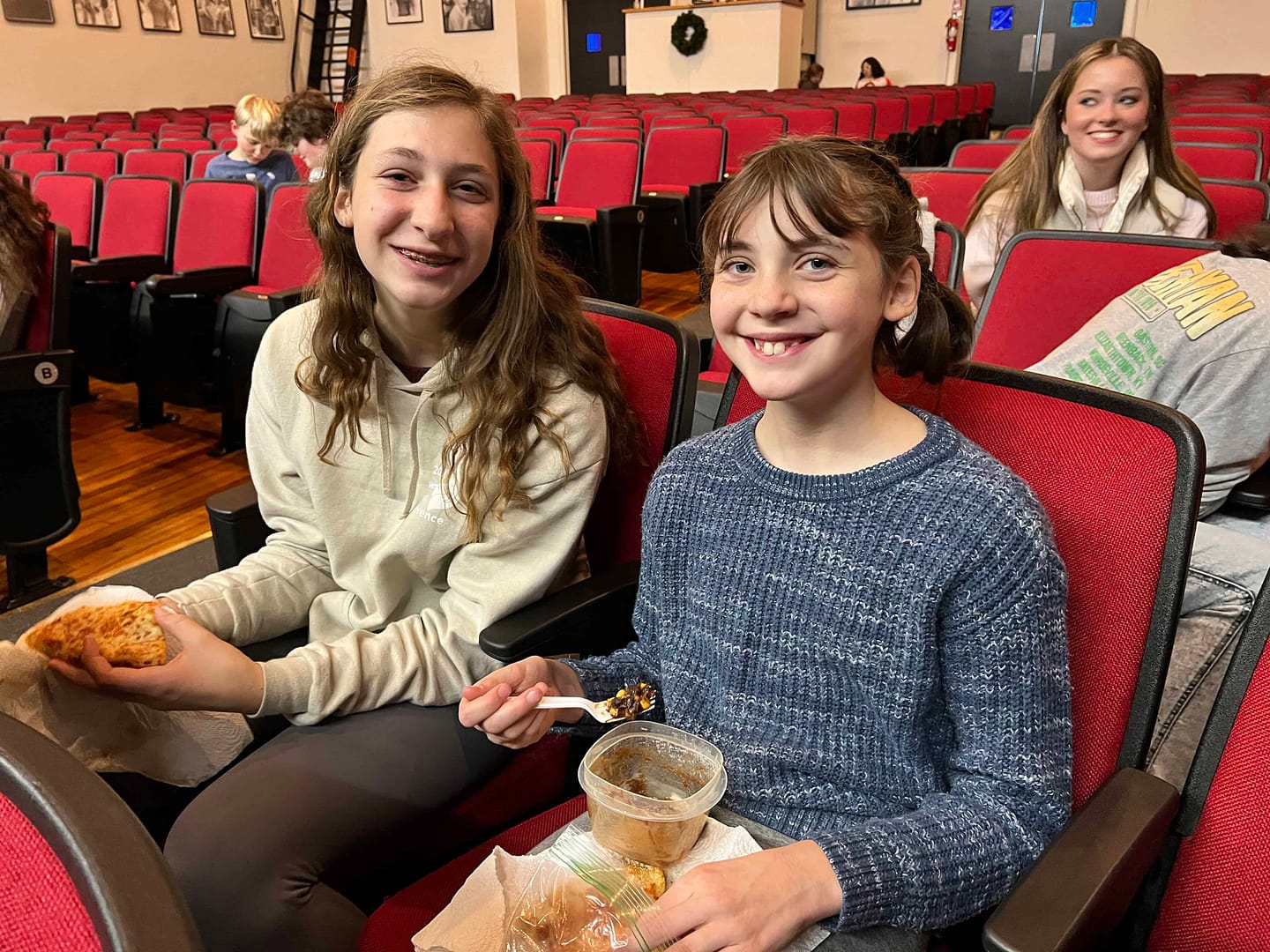 girls eating lunch in theater seats