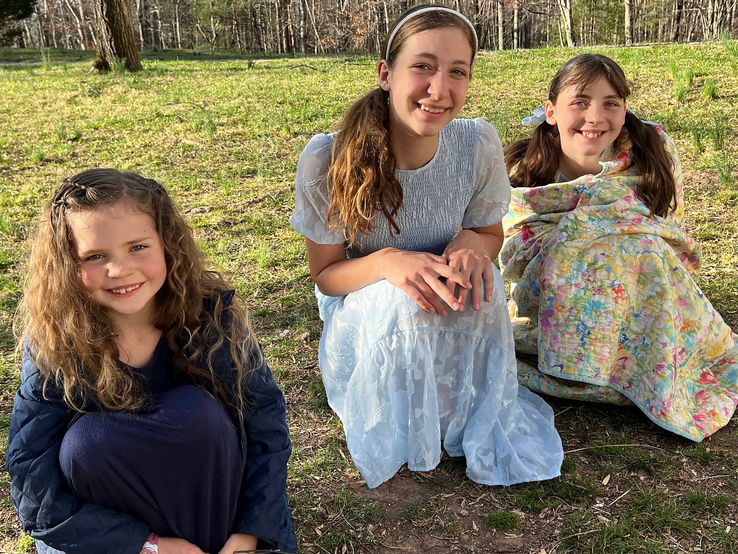 3 girls looking at the possum they caught