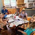 5 kids doing homeschool at the table