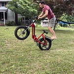 boy riding e-bike on one wheel-risky play