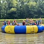 cousins on water trampoline on lake