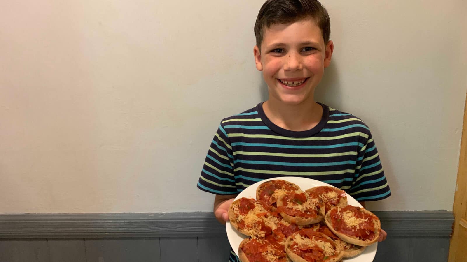 8 year old boy making English muffin pizzas