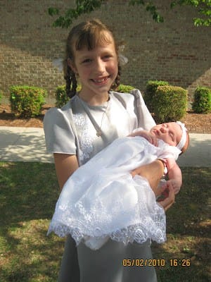 9 year old holding newborn sister