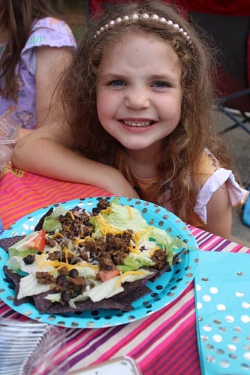 girl eating taco salad at a picnic table