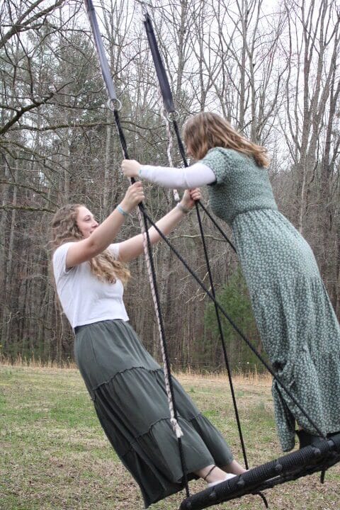 sister missionaries playing on spiderweb swing