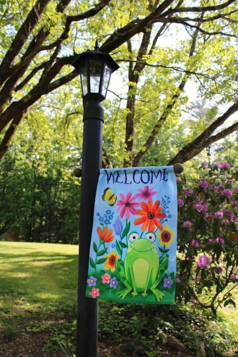 spring welcome flag in a large and shady yard