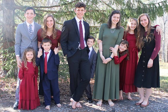 10 children wearing Christmas colors for family picture