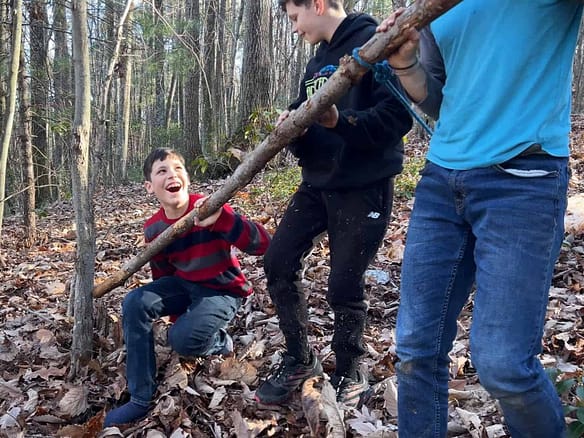 3 brothers dragging a log and 1 fell down