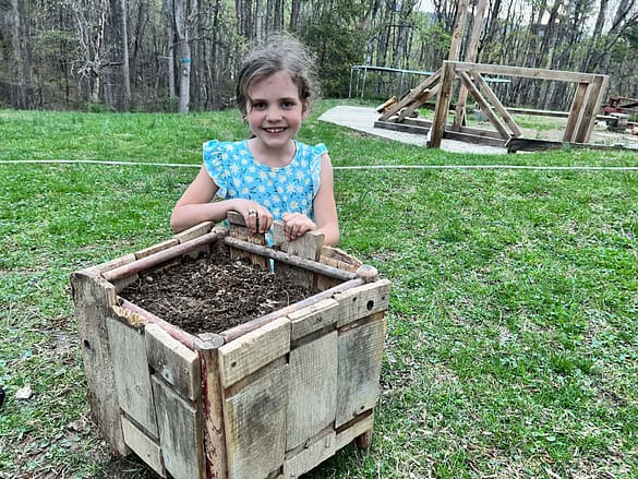girl with wooden planter after planting seeds