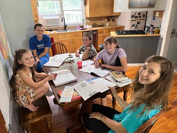 5 kids doing homeschool at the table
