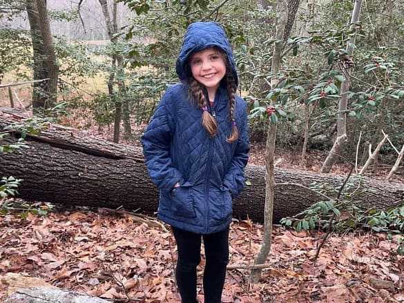 Girl in the woods looking for holly