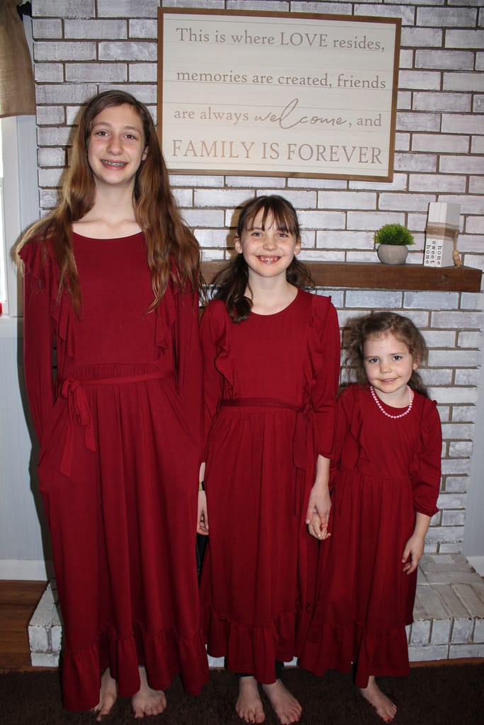 3 young girls wearing matching red dresses for valentines day
