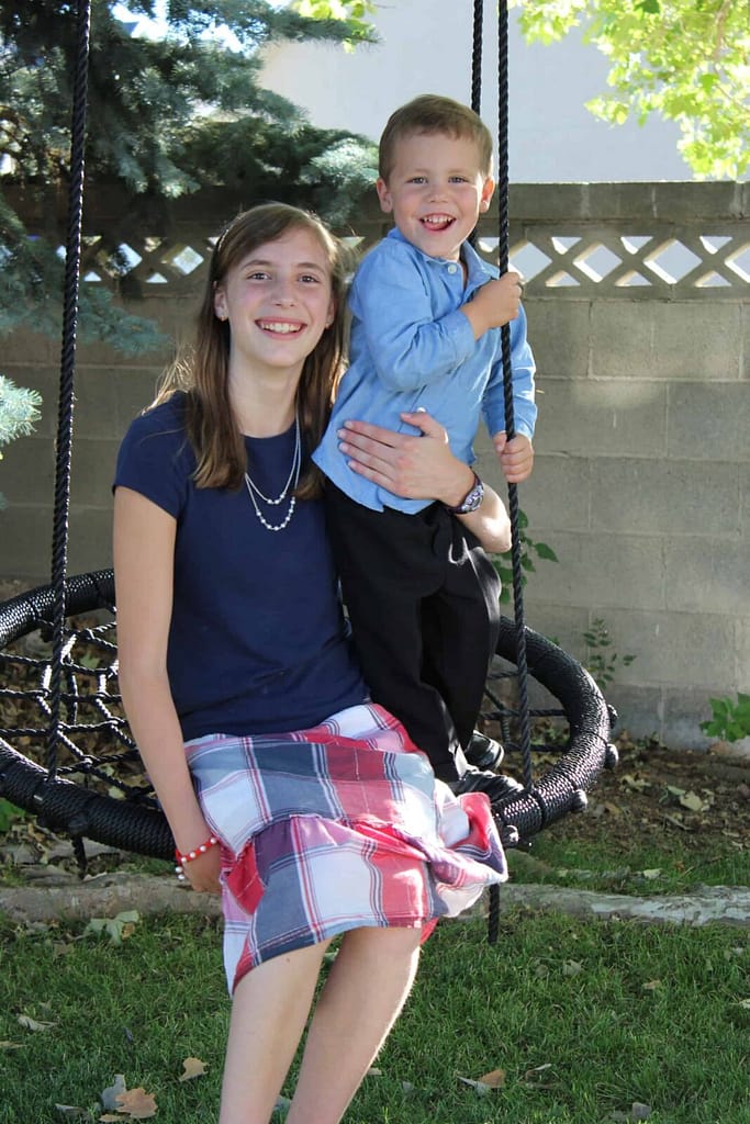 sister and brother on spiderweb swing